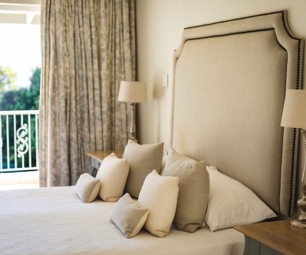 General view of luxury sunny bedroom with large bed and night tables. interior design and home decoration concept.