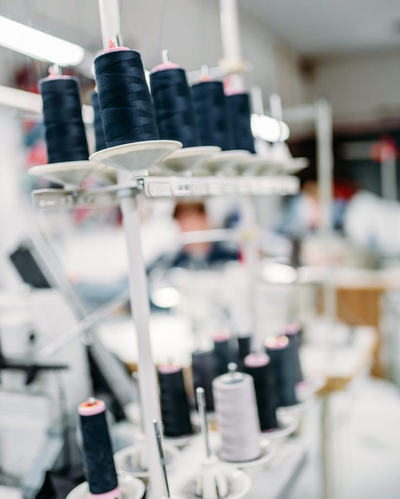 Black threads on spools closeup, overlock machine, sewing material, yarn on bobbins macro, tailoring or dressmaking equipment